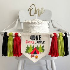 a birthday cake with tassels and a one happy camper banner