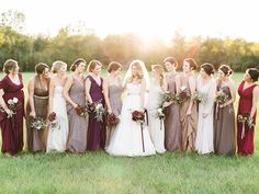 a group of women standing next to each other on top of a lush green field