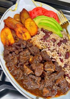 a white plate topped with meat, rice and veggies