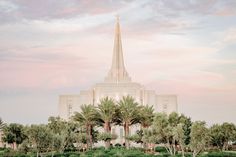 palm trees in front of a large building with a steeple on it's side