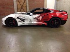 a red and white sports car parked in a garage