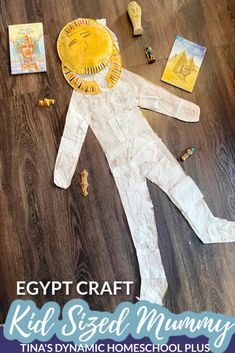 an egyptian paper doll laying on top of a wooden floor with the title egypt craft kid sized mommy