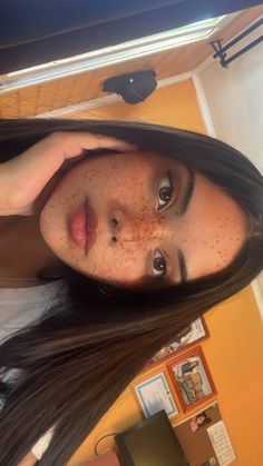 a woman with freckles on her face posing for a photo in front of a mirror