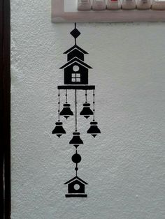 a clock with bells hanging from it's side on the wall next to a light switch