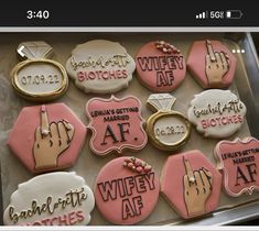 a box filled with lots of decorated cookies on top of a table next to each other