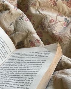 an open book sitting on top of a bed