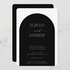 the black and white arch wedding card is displayed on a marble table with flowers in it