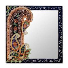 a decorative mirror with an ornate design on the front and back side, hanging from a wall