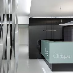 the interior of an office building with white floors and black walls, as well as a reception counter