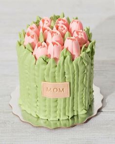 there is a green cake with pink icing in the shape of tulips