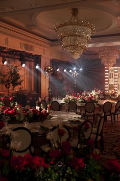 a banquet hall with tables and chairs set up for a formal function, lit by chandeliers