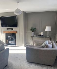 a living room filled with furniture and a flat screen tv mounted on the wall above a fireplace