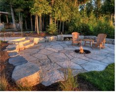 an outdoor fire pit with chairs around it