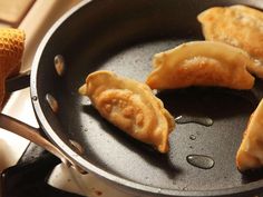 some dumplings are cooking in a frying pan