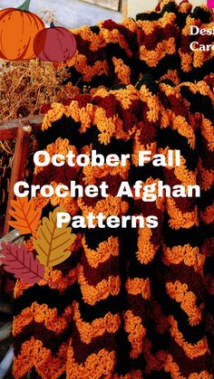 an orange and black crochet afghan with fall leaves on it, sitting in front of hay bales