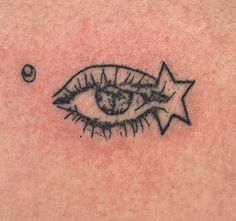 a close up of a person's chest with an eye and star tattoo on it