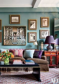 a living room filled with furniture and pictures on the wall above it's coffee table