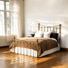 a bed sitting on top of a hard wood floor next to a window in a bedroom