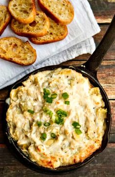 a cast iron skillet filled with cheesy bread and topped with green onions