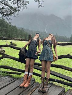 two young women standing on a wooden bridge