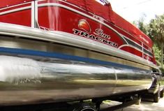 a red and white boat is parked on the street