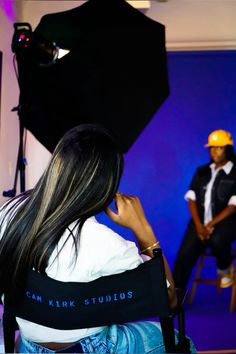 a woman sitting in a chair with a camera behind her