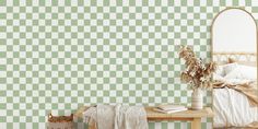 a green and white checkered wallpaper in a bedroom with a bed, mirror and table