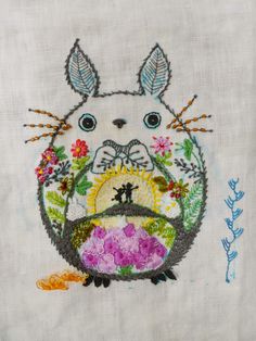 the embroidery design is very colorful and has an image of a cat with flowers on it