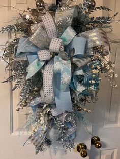 a blue and silver christmas wreath hanging on the front door