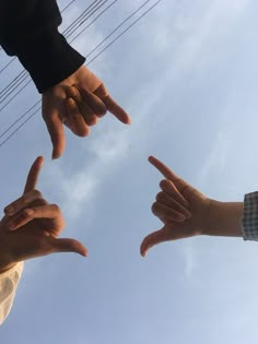 four people pointing their fingers at the sky