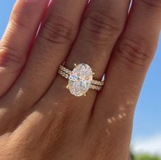 a woman's hand holding an engagement ring with a large diamond on the band