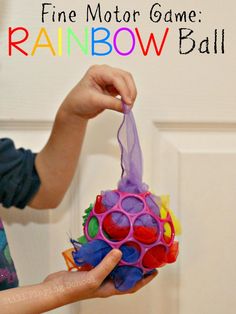 a person holding a toy in their hand with the words fine motor game rainbow ball on it