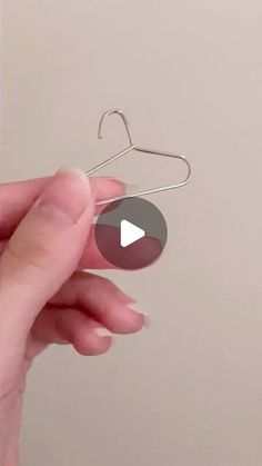 a hand holding a metal hanger with a video playing on it's side