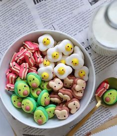 a bowl filled with lots of colorful food next to a cup of milk and spoon