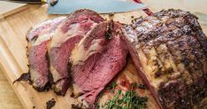 a large piece of meat sitting on top of a cutting board next to a knife