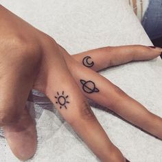 two hands with tattoos on them are sitting next to each other, one has a sun and the other is a crescent