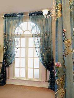 a room with curtains and chandelier hanging from the ceiling in front of a window