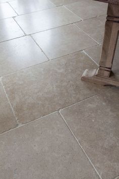 a wooden bench sitting on top of a floor next to a tiled flooring area