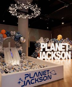 the planet jackson sign is surrounded by balloons and other decorations in an office space with a chandelier hanging from the ceiling