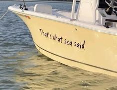 a white boat in the water with writing on it that says, that's what sea said