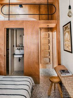 a bedroom with wood paneling and a bed in the corner next to a sink