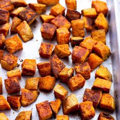 cooked cubed potatoes on a baking sheet ready to be baked in the oven or used as an appetizer