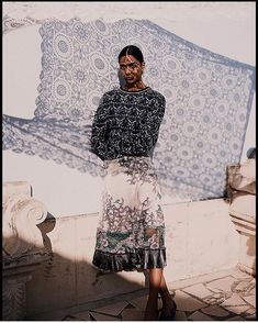 a woman standing in front of a wall with a painting on it's side