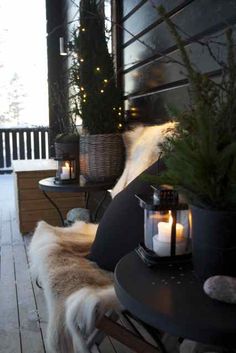 a dog standing on a porch next to a table and chairs with candles in front of it