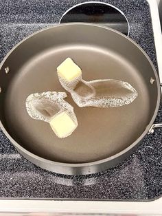 two pieces of butter are being cooked in a frying pan on the stove top