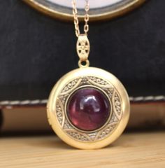 This raw brass locket has been layered with a vintage brass bezel  and set with a lovely 16mm Amethyst Gemstone cabochon.  It has been polished to a warm golden tone and sealed with a wax polish.  In time it will darken but can be polished back to golden or left to form its natural patina if desired. The locket is 30mm with 10mm bail and is hung from a matching 1x2mm brass link chain and finished with a brass lobster clasp. It will arrive in a velvet gift pouch.