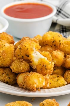 some fried food on a white plate with dipping sauce