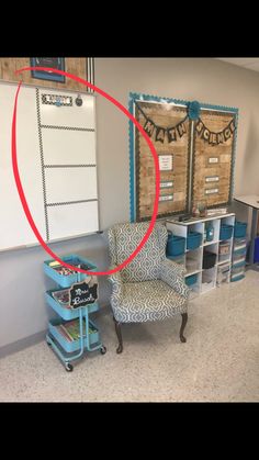 a room with two chairs and several bins on the floor, in front of a whiteboard