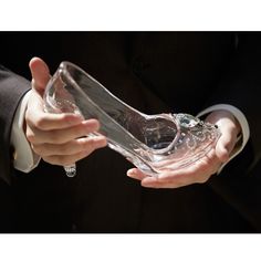 a person in a suit holding a glass vase with water on it's side