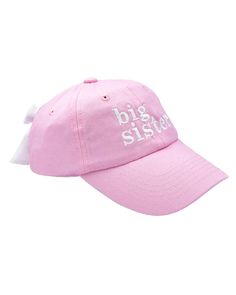 a pink baseball cap with the words big sister on it and an arrow at the front